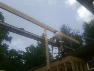 Carpenter setting a ridge beam over a new addition frame — Ice Dam Removal by Roofing Brothers in Estill Springs