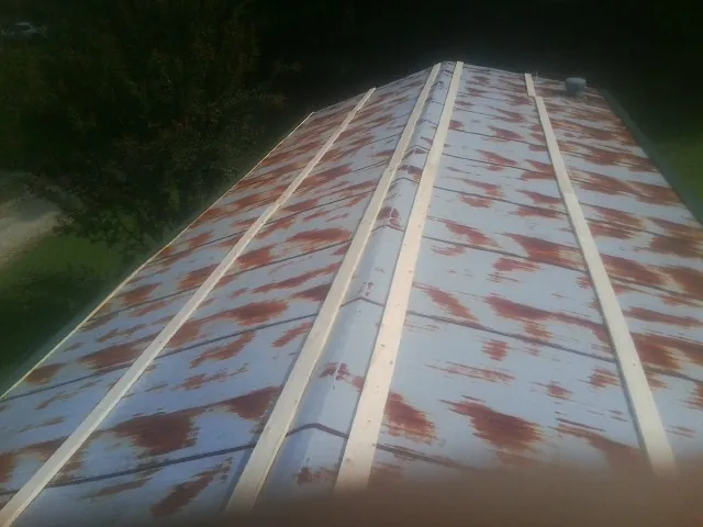 Rusted metal roof panels with new wood purlins before replacement — Storm Damage Roof Repair in Estill Springs by Roofing Brothers
