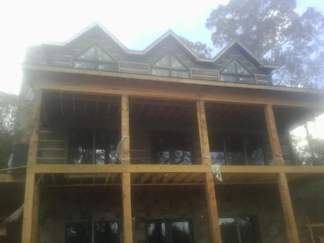 Dormers and porch framing on a large log home under construction — Roof Coating work by our crew in Estill Springs