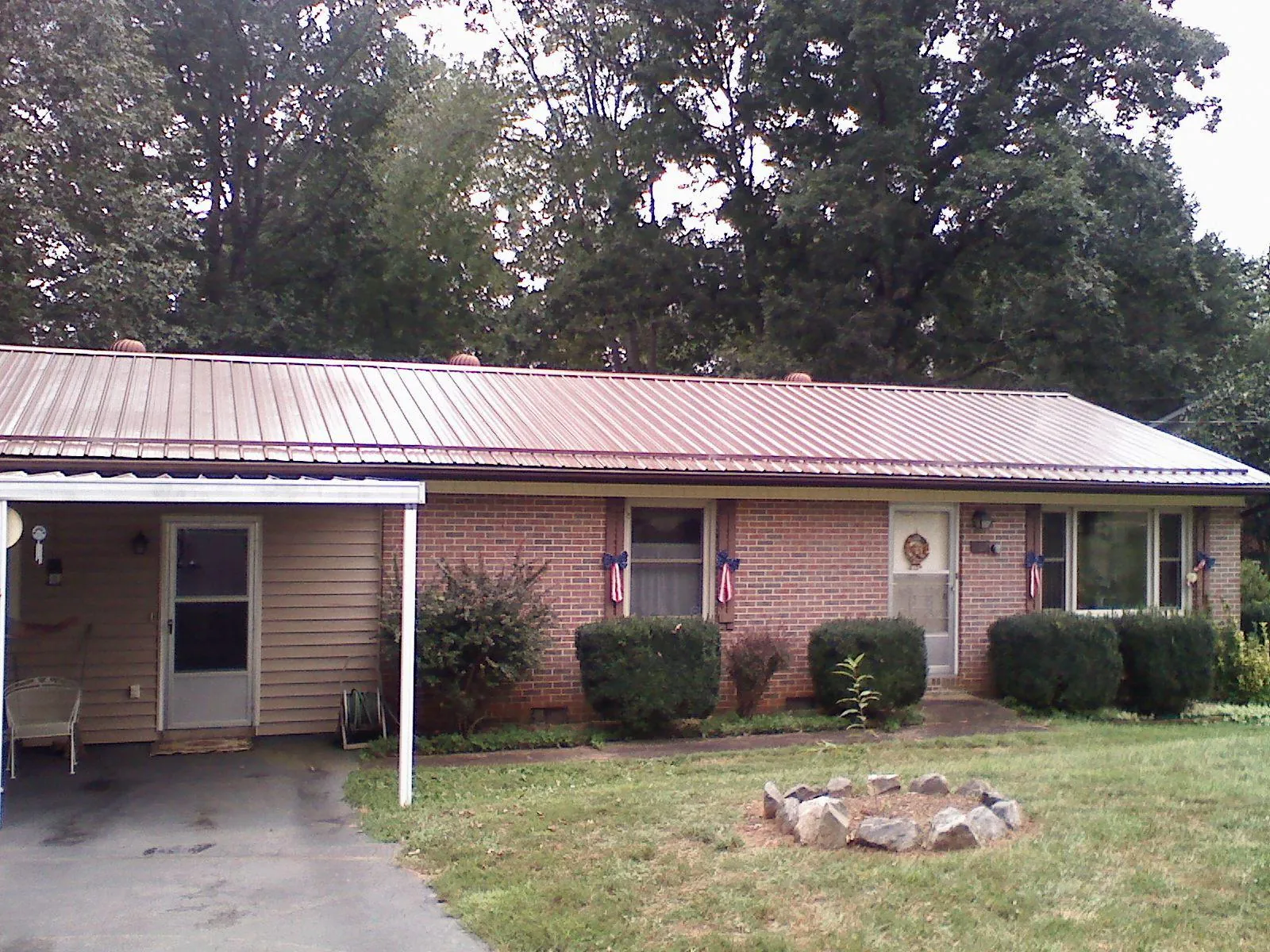 Bronze metal roof and carport on a brick ranch home — Roof Repair work by our crew in Estill Springs